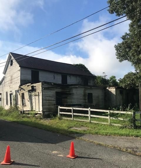 An old barn with a fence in front of it