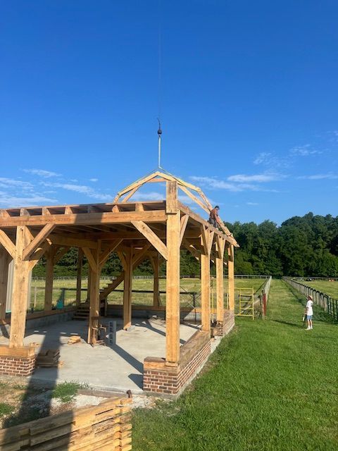 A wooden structure is being built in a field.