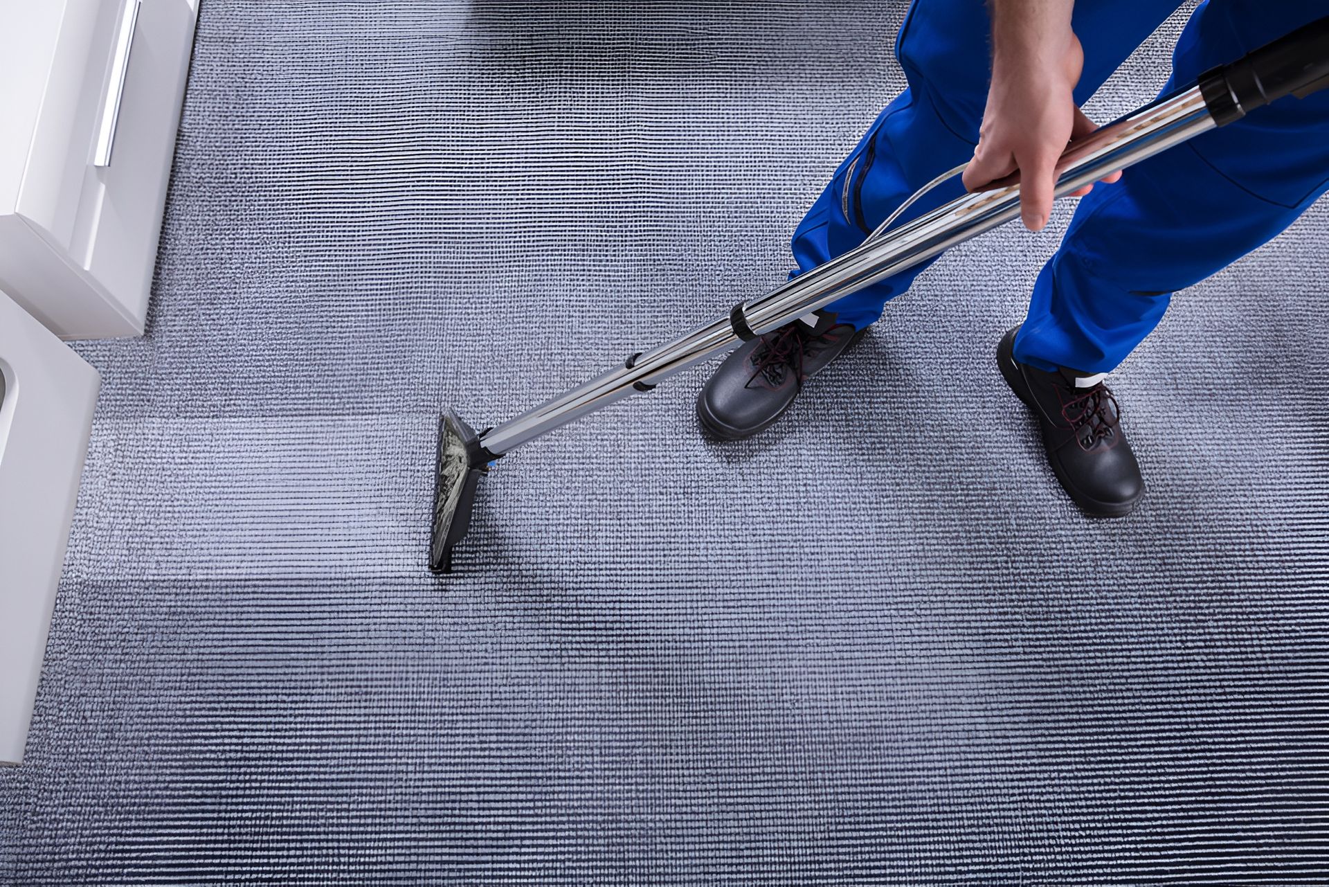 Person in Blue Pants Vacuuming Carpet — Cairns Local Cleaning Services in Woree, QLD