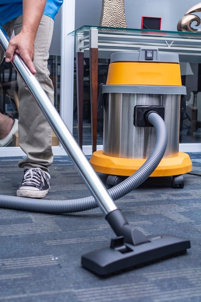 Person Vacuuming a Carpeted Office Floor — Cairns Local Cleaning Services in Woree, QLD