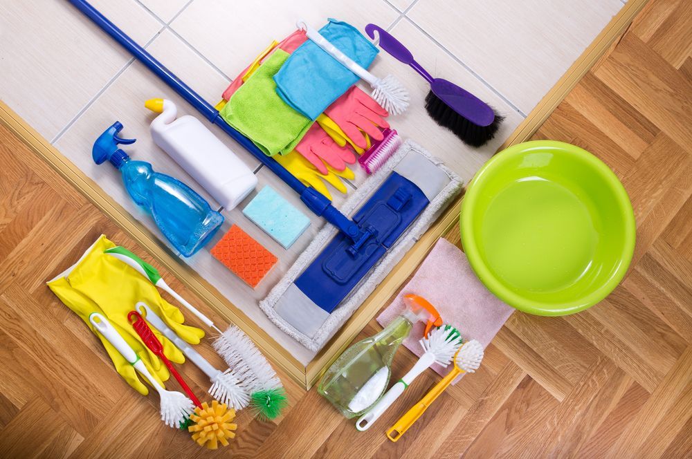 Cleaning Supplies Arranged on Wood and Tile Floor — Cairns Local Cleaning Services in Cairns City, QLD