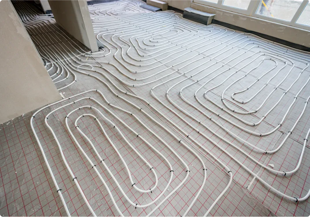 White pipes in a layered pattern installed on a floor, likely for radiant heating.