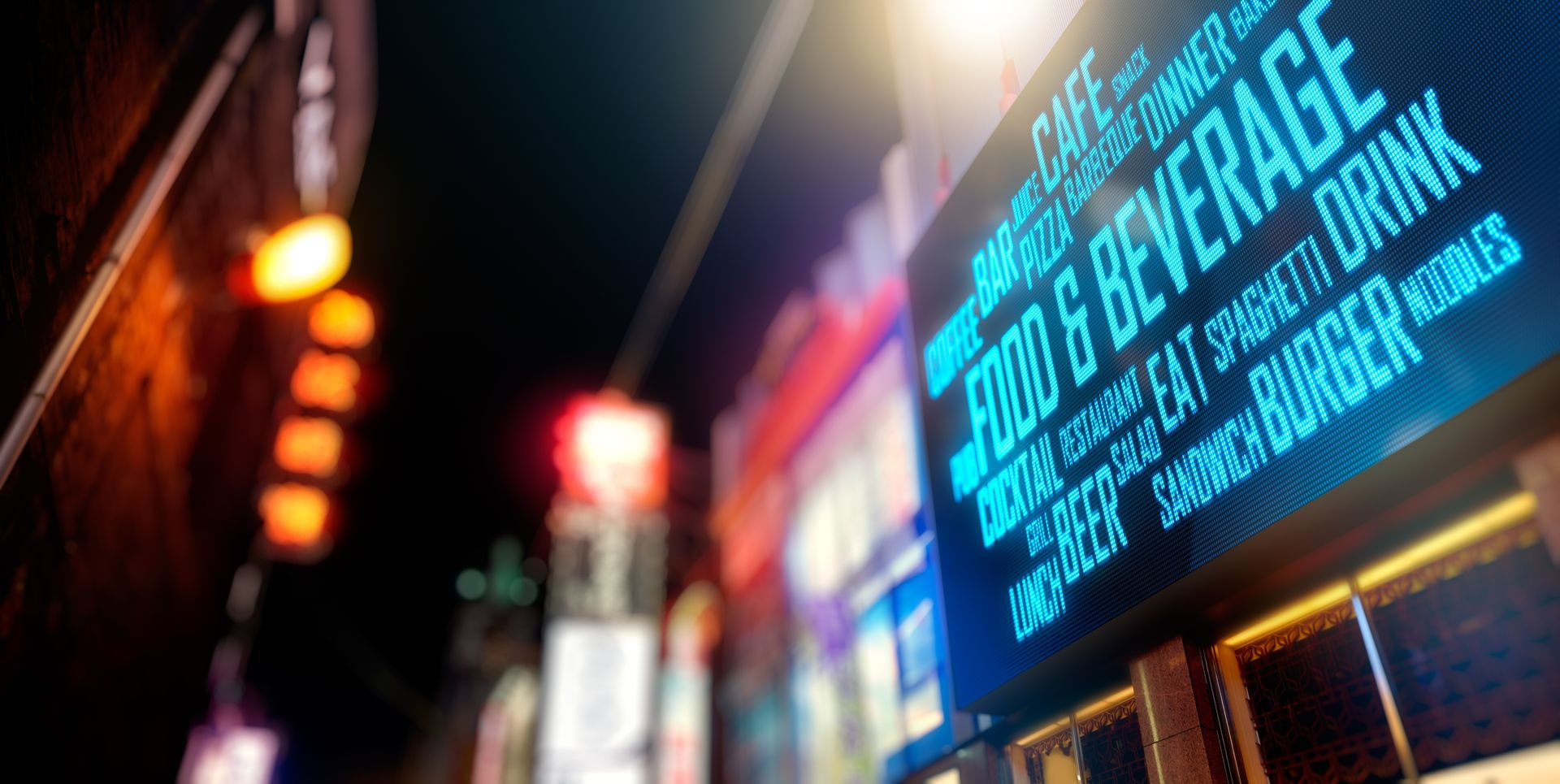 Neon food and beverage sign glowing above a city street at night.