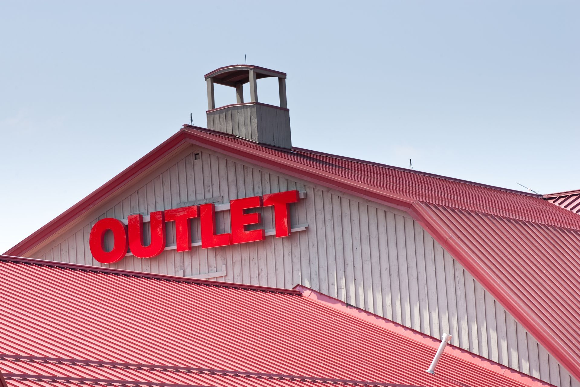 Large red outlet sign with a red metal roof, showcasing business signs in Phoenix AZ.] 