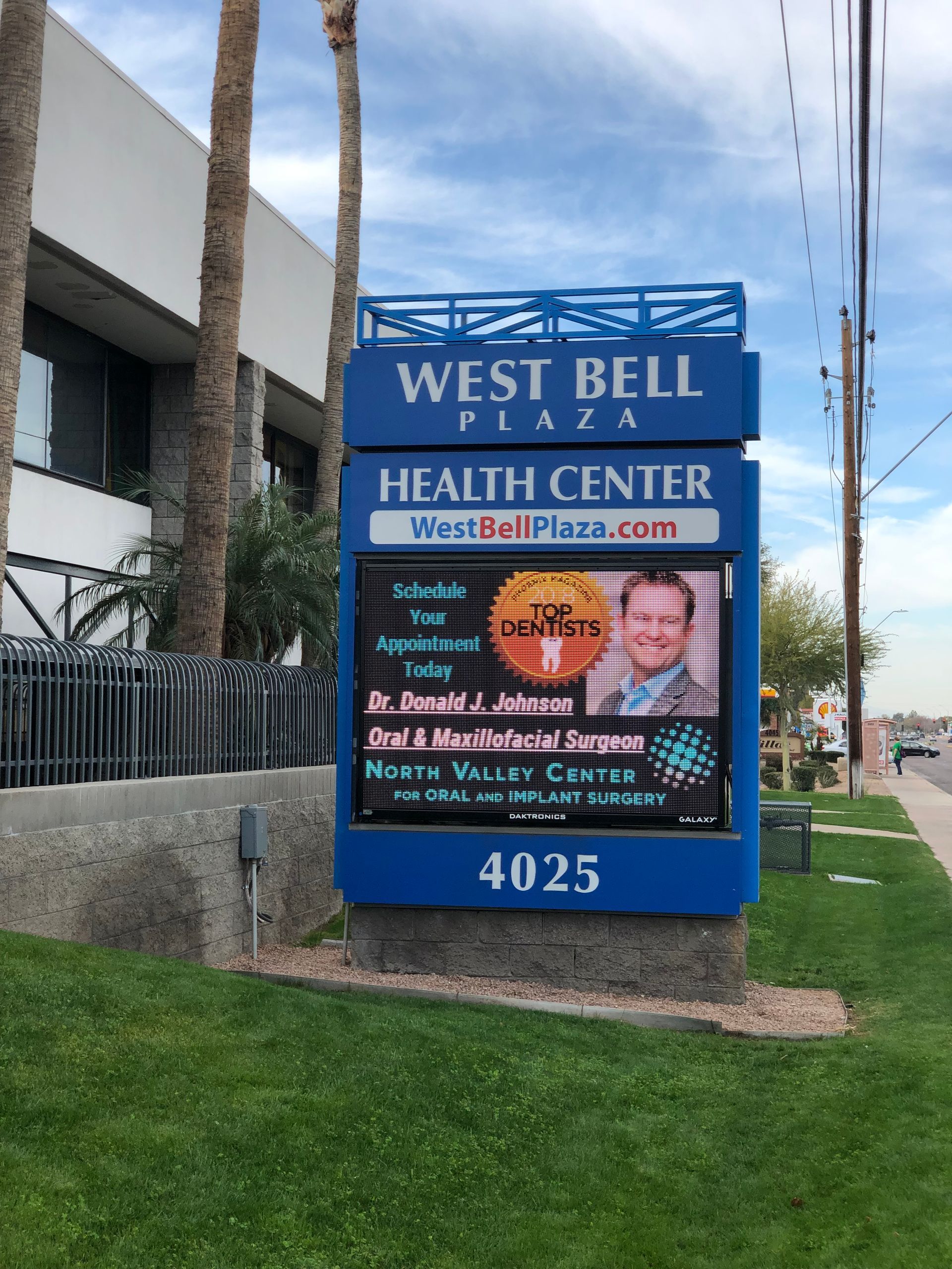 West Bell Plaza Health Center sign, digital display with doctor photos and contact information, blue frame, 4025 address.