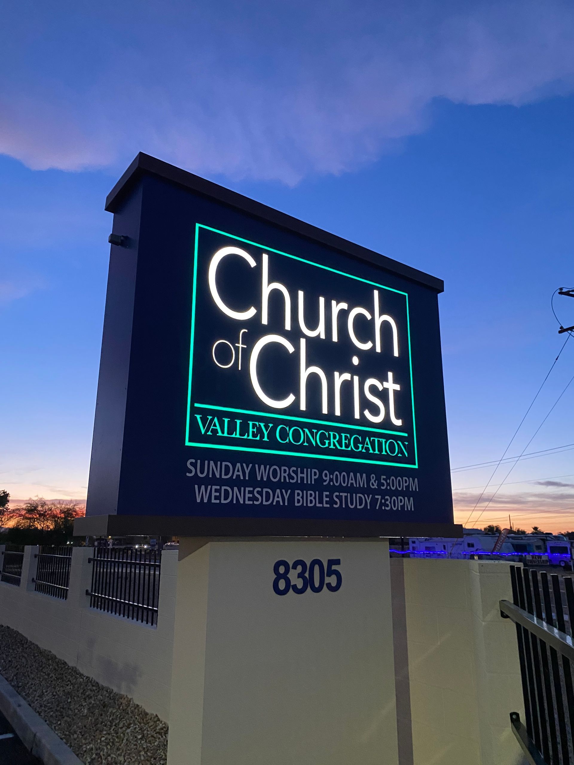 Church of Christ sign with illuminated white text, blue background, and service times. Located at 8305.