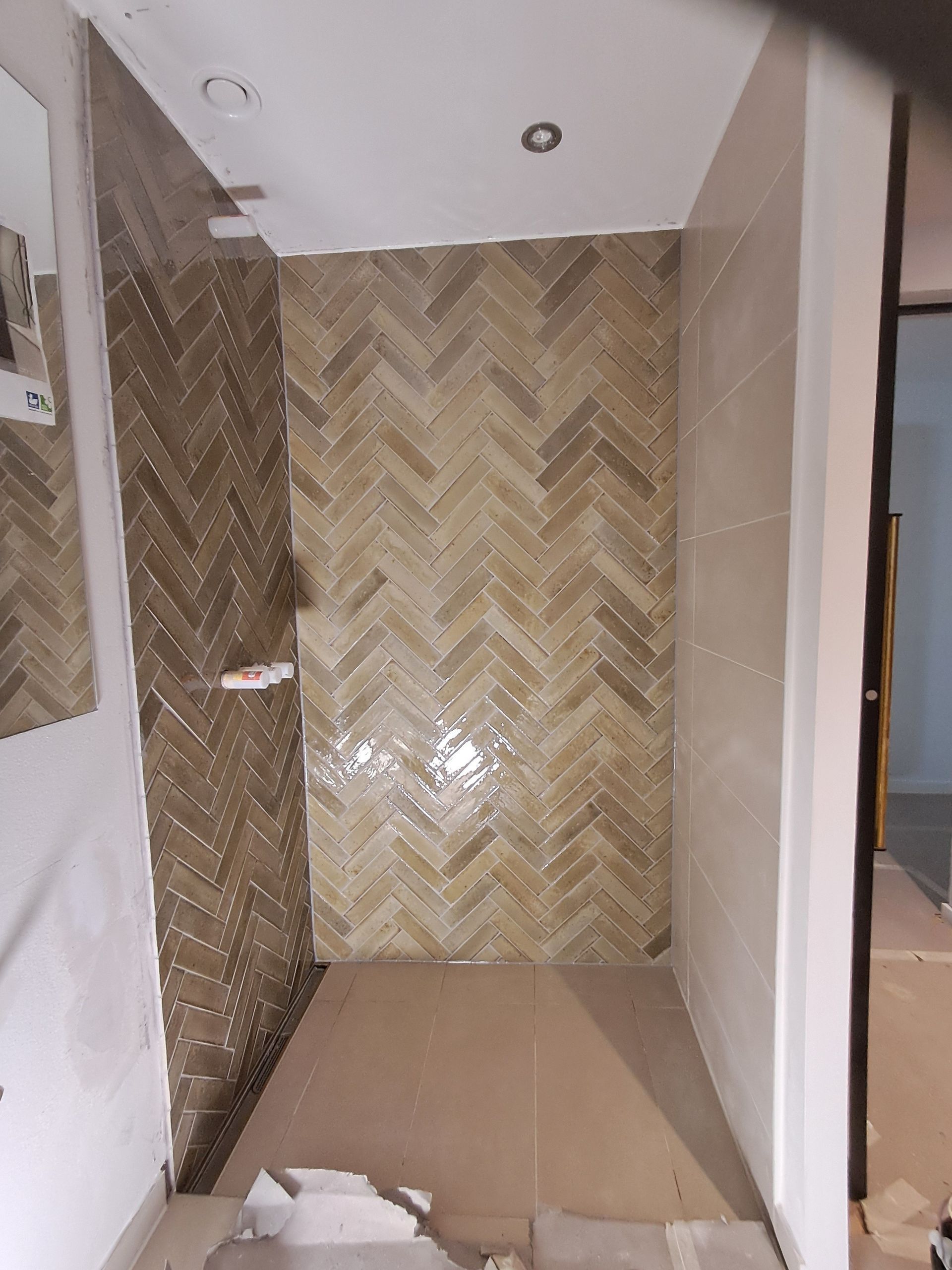 Et badeværelse med sildebensmønster på væggen.