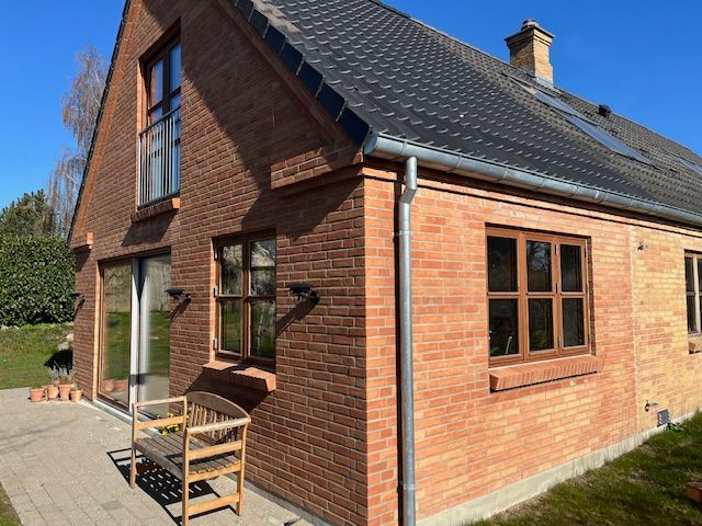 Et murstenshus med en bænk foran