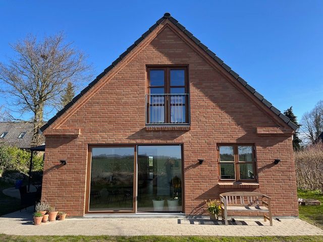 Et murstenshus med en bænk foran