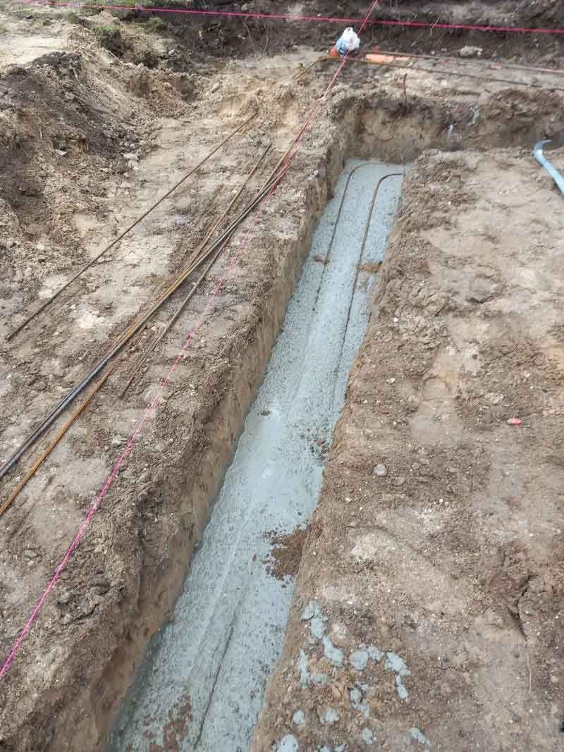 En rende bliver fyldt med beton og elektriske ledninger.