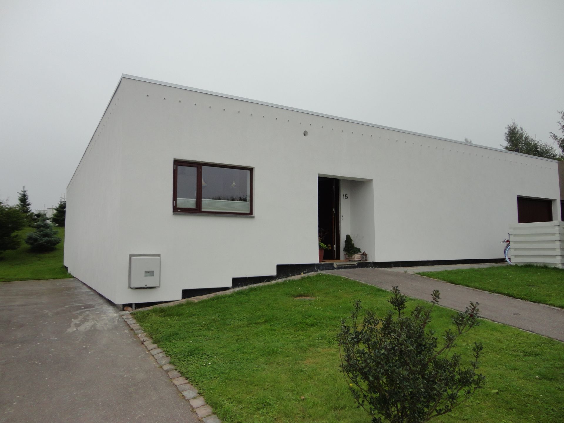 Et hvidt hus med en græsplæne foran