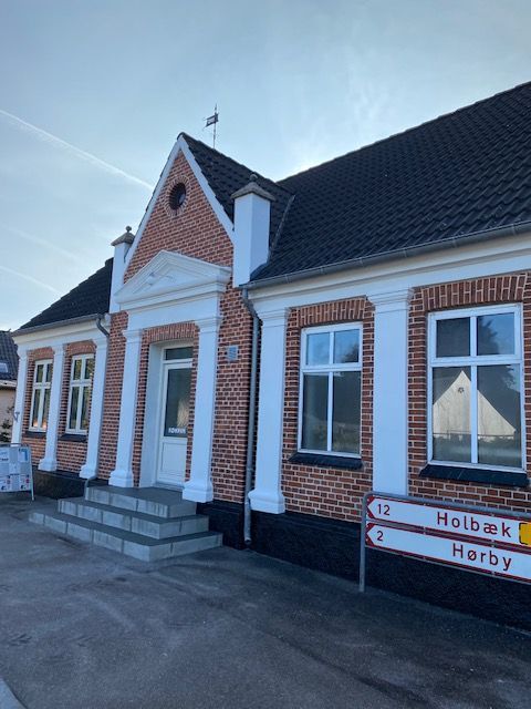 En murstensbygning med et skilt, hvor der står holbak