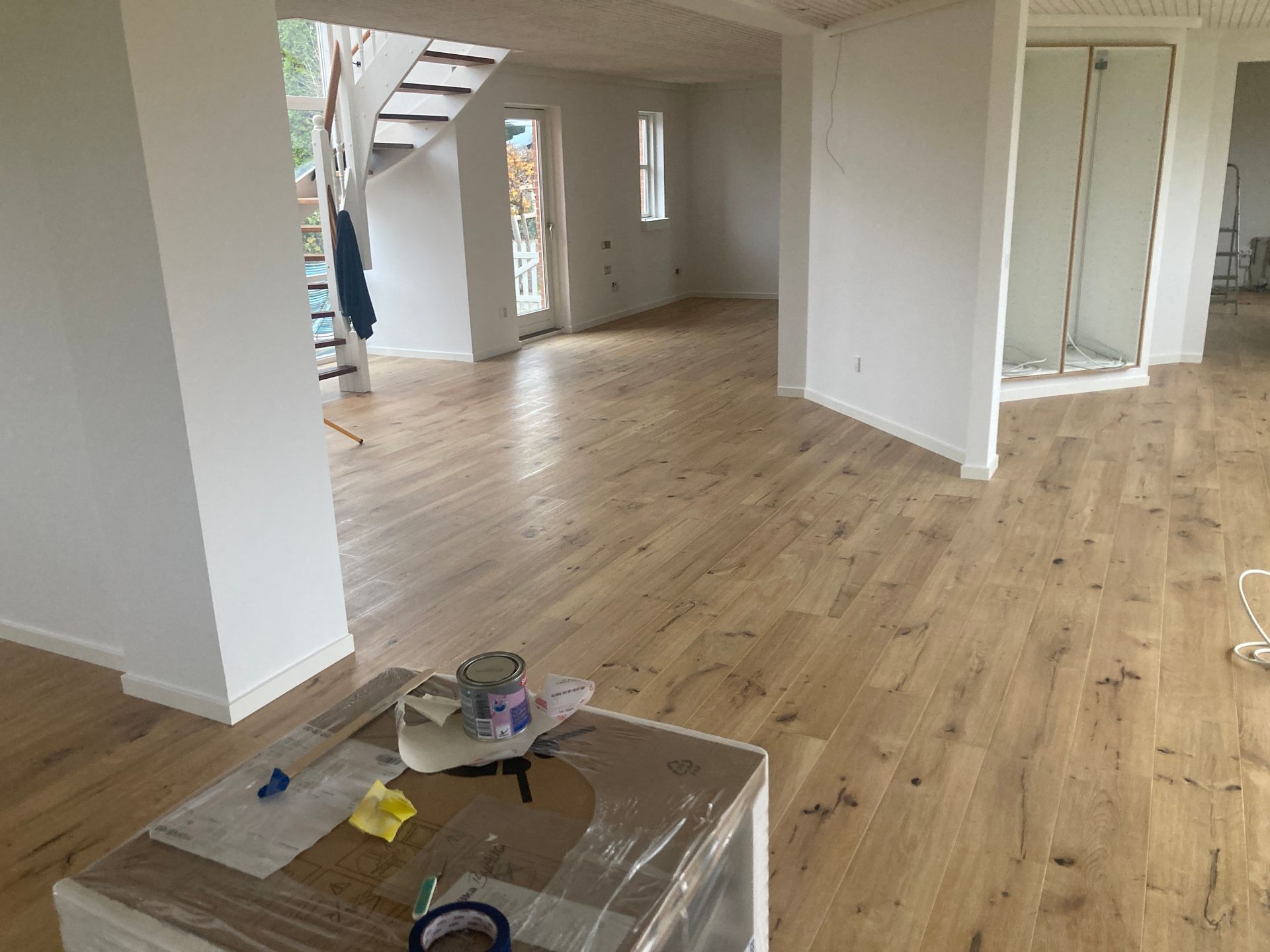 Der er et bord i midten af ​​rummet med trægulv.