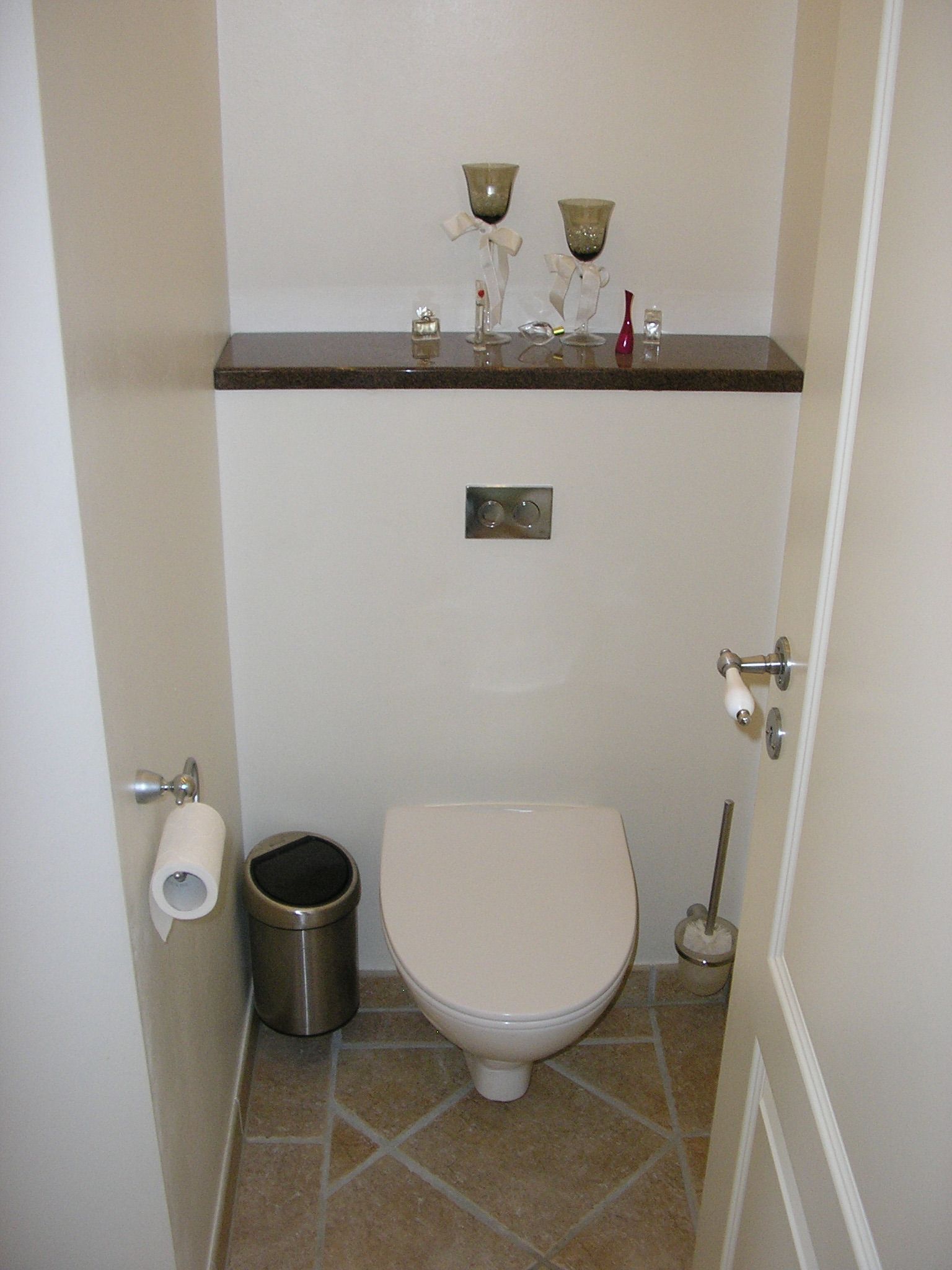 Et badeværelse med toilet og skraldespand