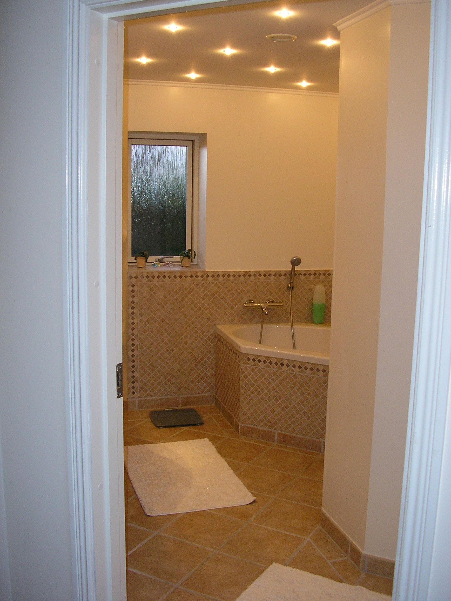 Et badeværelse med badekar og et vindue