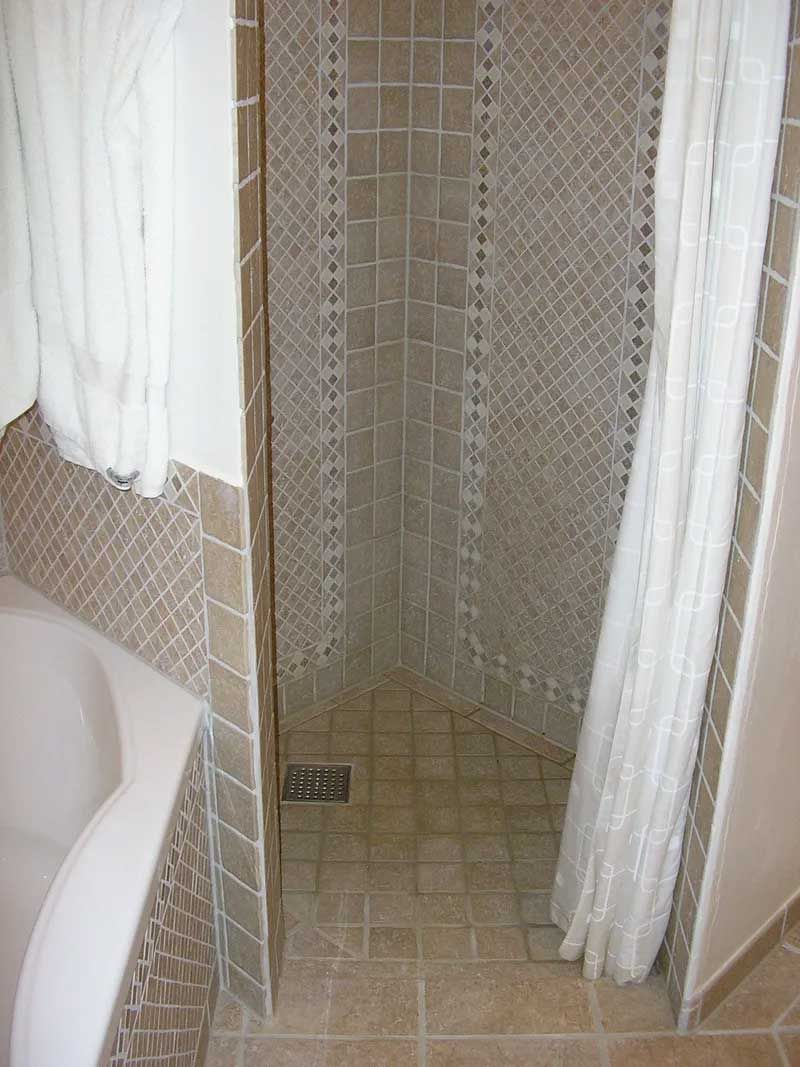 Et badeværelse med badekar og bruser med hvidt gardin