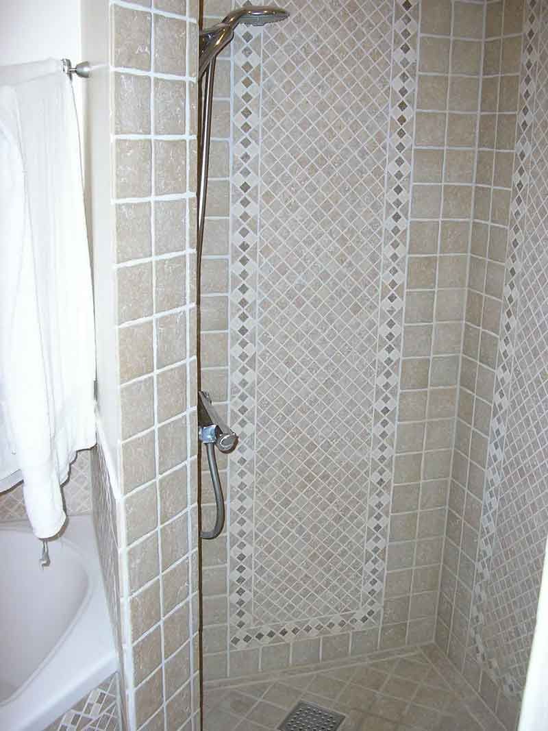 Et badeværelse med brusekabine og badekar.