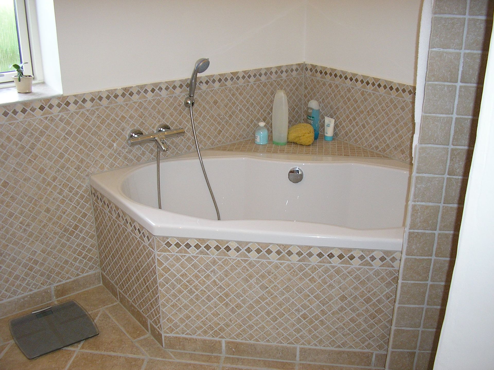 Et badeværelse med badekar og vægt på gulvet