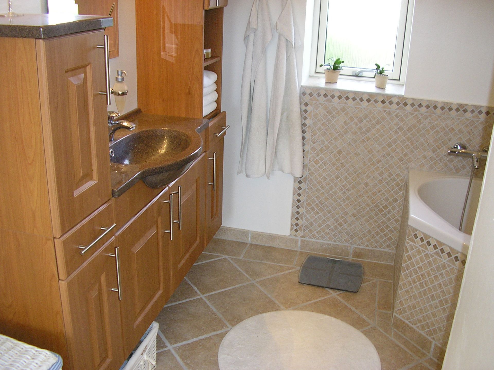 Et badeværelse med en vask, et badekar og et vindue