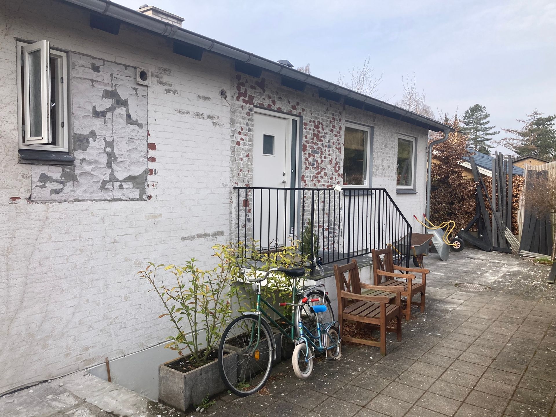 Et hvidt hus med en cykel parkeret foran.