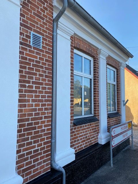 En murstensbygning med et skilt, hvor der står parkeringsforbud