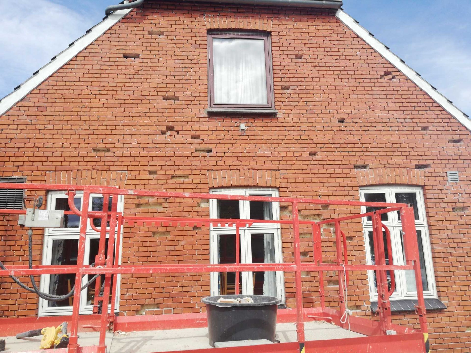 En murstensbygning med en rød stige foran