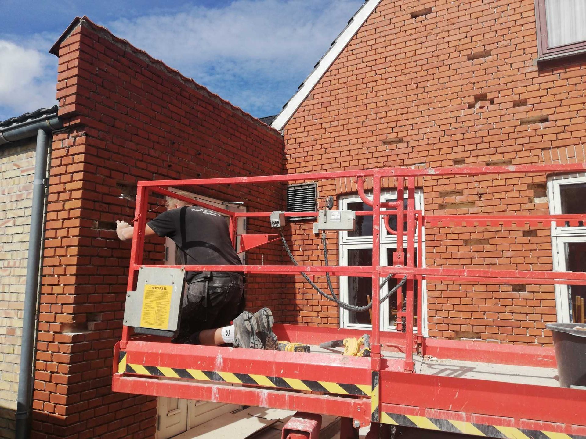 En mand arbejder på en mur på en elevator.