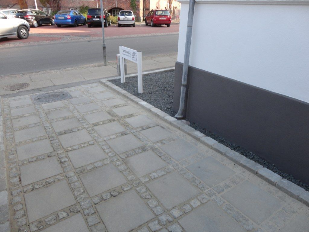 En parkeringsplads med biler parkeret foran en bygning