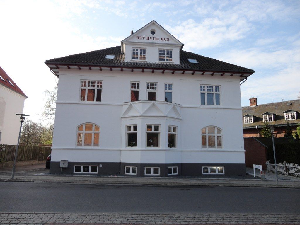 En stor hvid bygning med et tag, hvor der står 'stadion' på