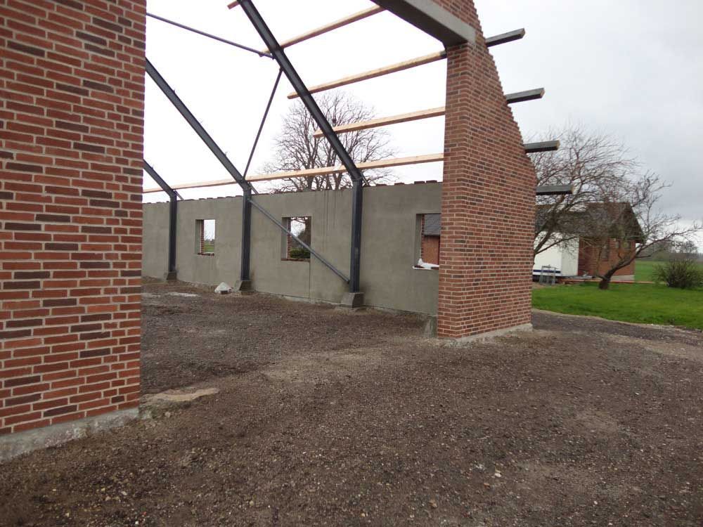 En murstensbygning under opførelse med en metalramme