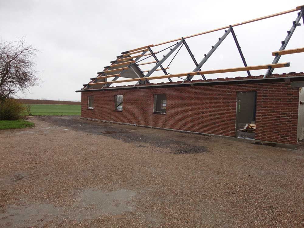 En murstensbygning med tag, der bygges