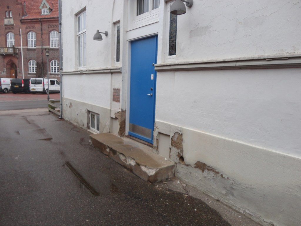 En blå dør er på siden af ​​en bygning