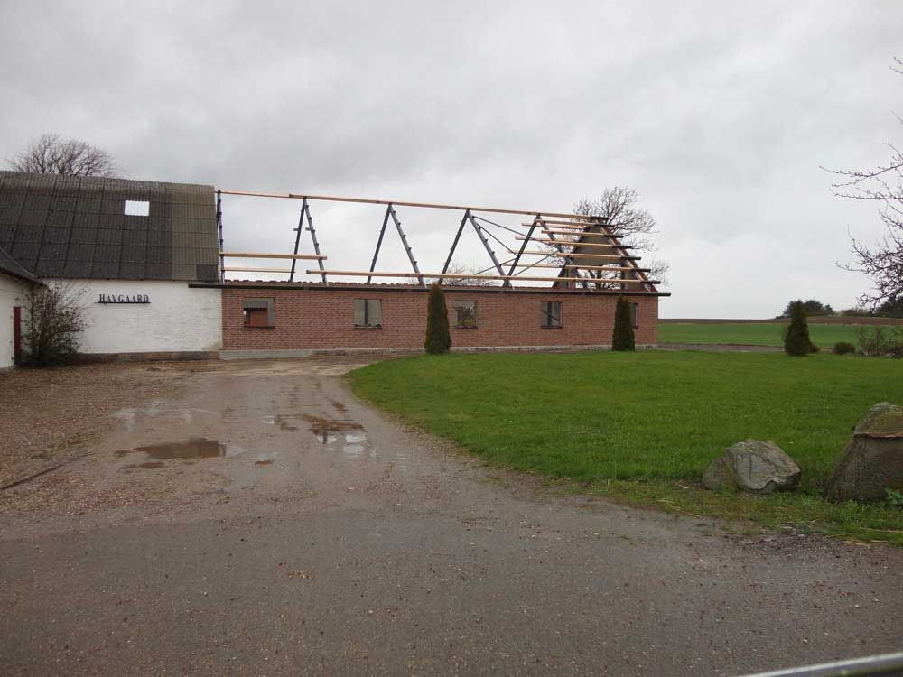 En murstensbygning med tag, der bygges