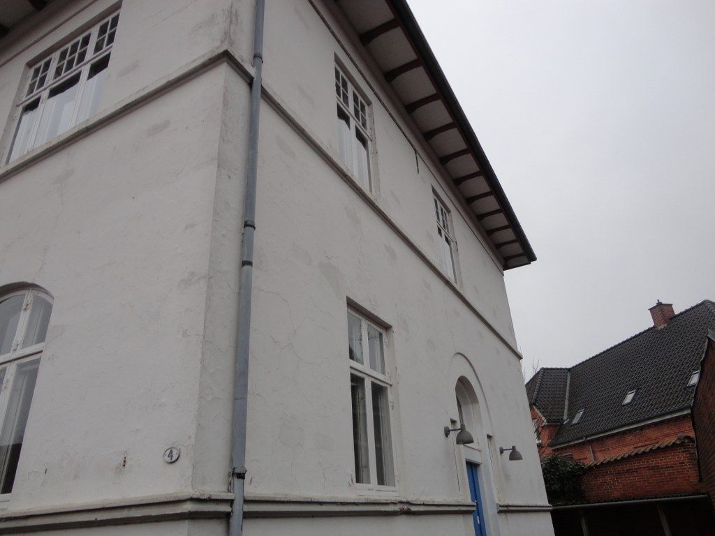 En stor hvid bygning med en blå dør