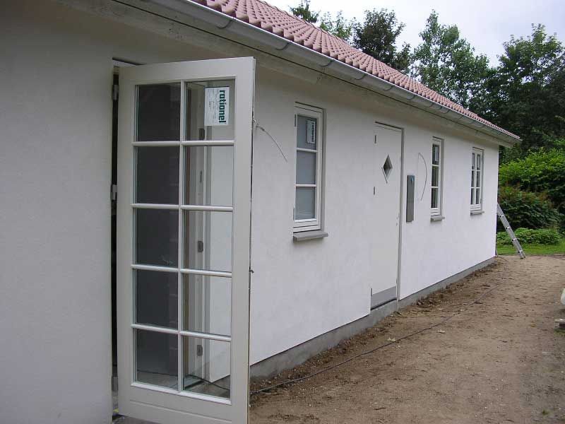 En hvid bygning med døren åben og et skilt, hvor der står 'petra' på