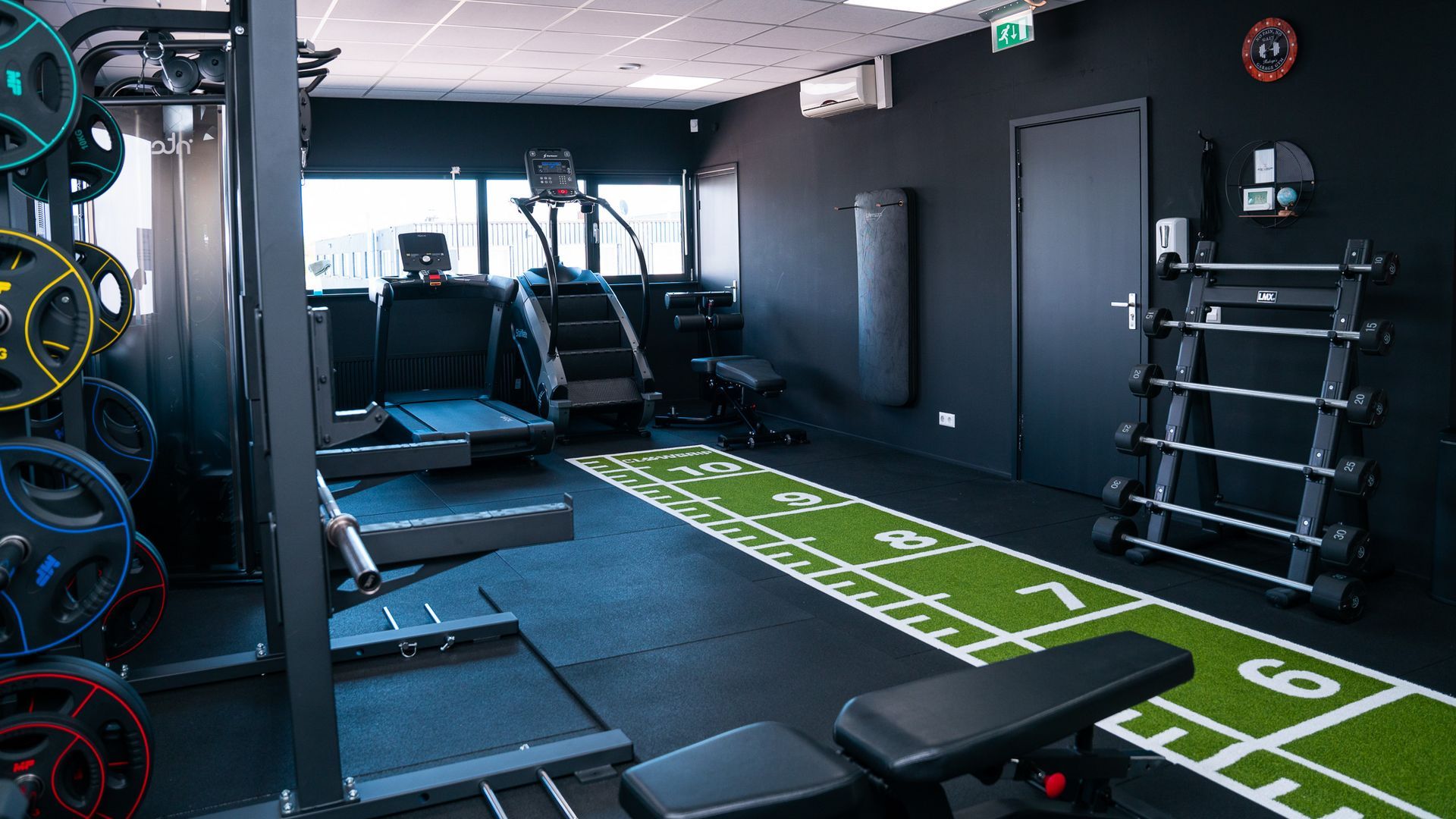 Een vrouw rijdt op een hometrainer in een sportschool terwijl ze naar muziek luistert.