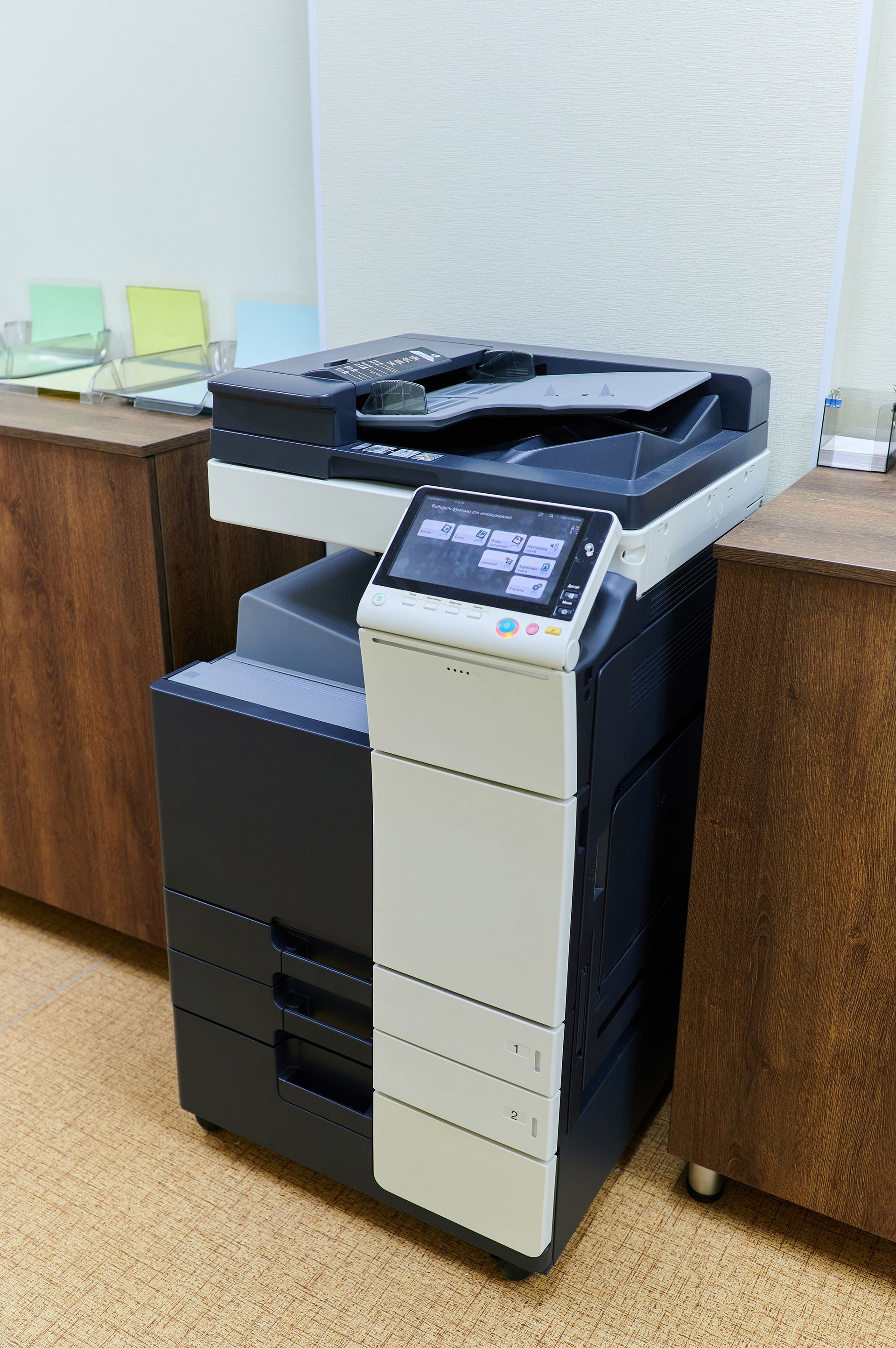 Multifunction printer on brown cabinets, in an office setting. Multifunction printer on brown cabinets, in an office setting.