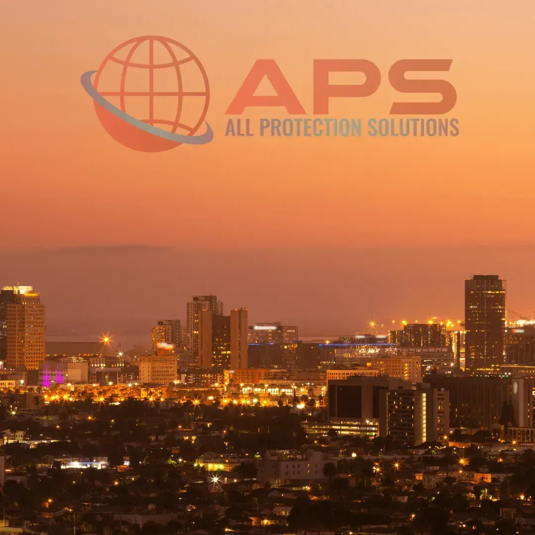 City skyline at sunset with APS All Protection Solutions logo overlaid in orange sky