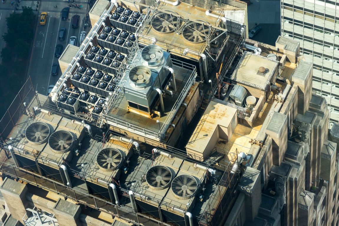 An aerial view of a building with a lot of HVAC fans on the roof