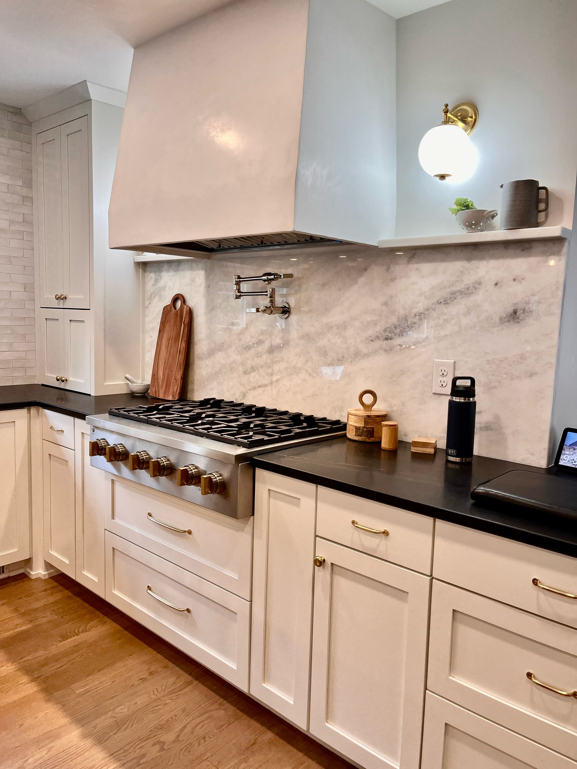 A kitchen with white cabinets and a stove top oven