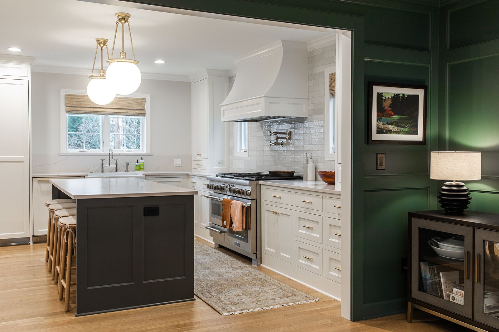 A kitchen with a large island and a green wall