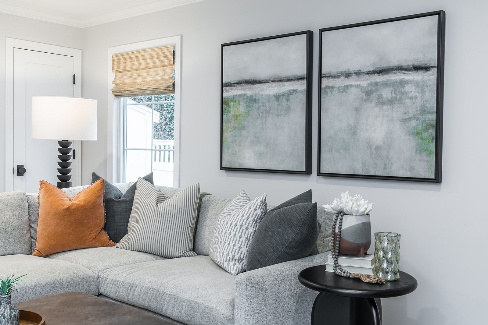 There are two paintings on the wall above the couch in the living room