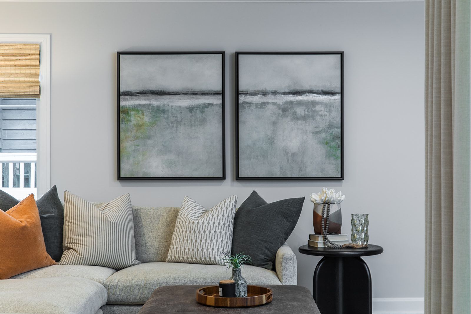 A living room with a couch and two paintings on the wall