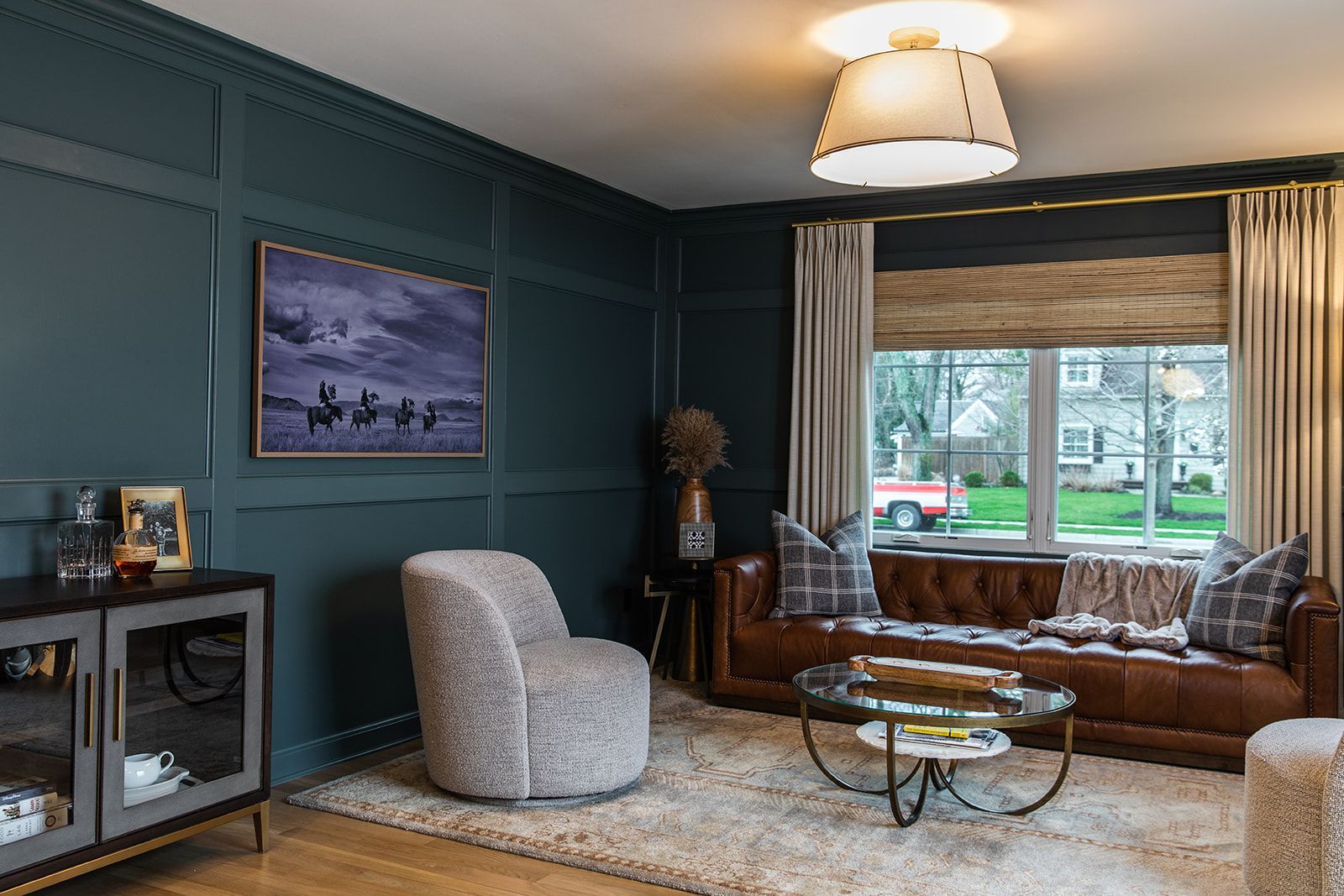 A living room with a coffee table and a picture on the wall.