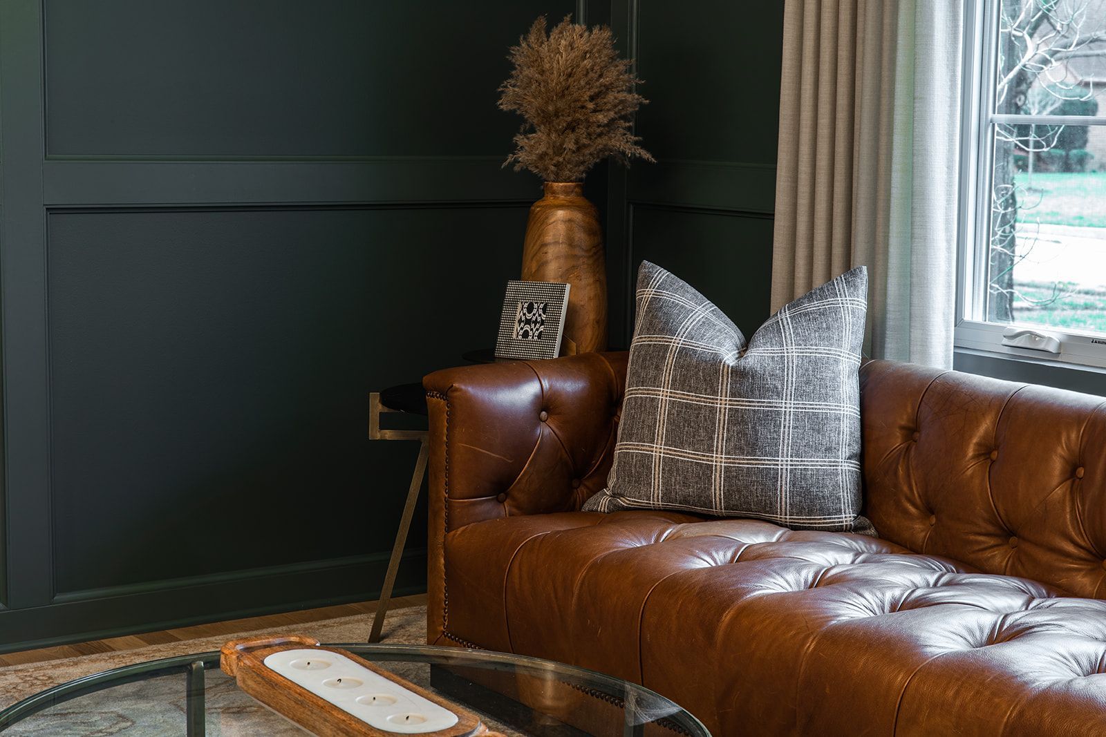 A living room with a brown leather couch and a glass coffee table