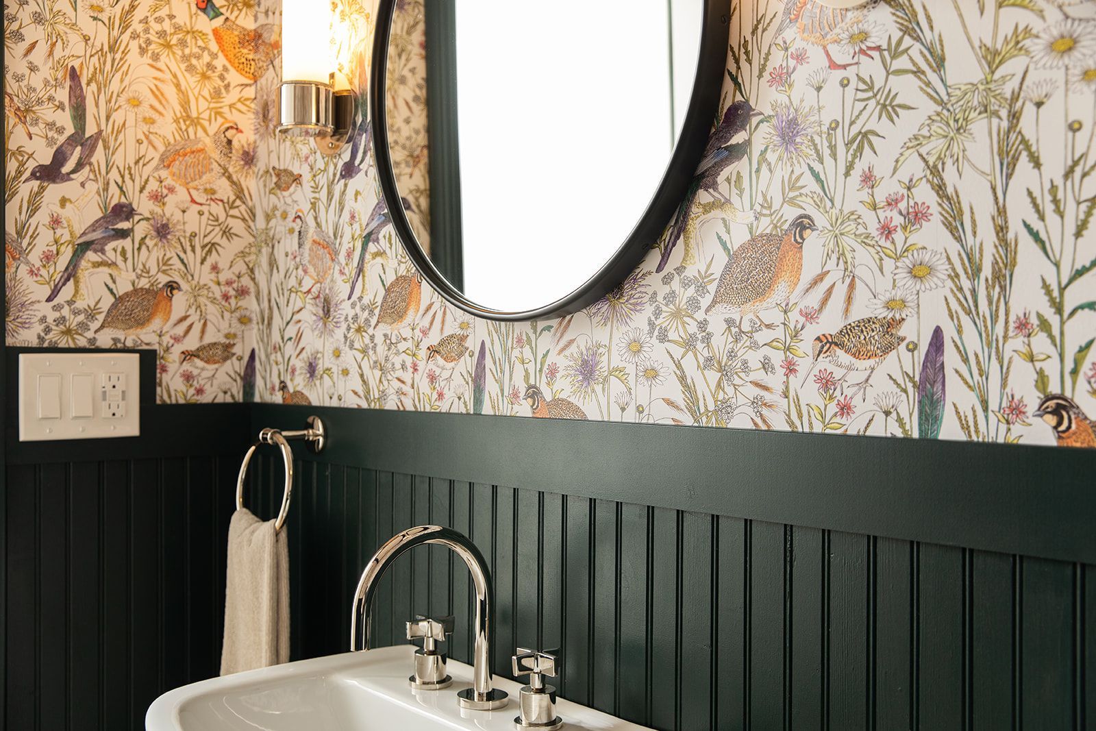 A bathroom with a floral wallpaper
