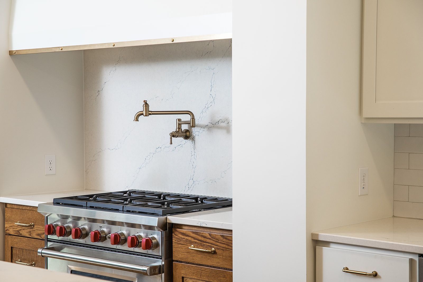 A kitchen with a stove and a faucet on the wall