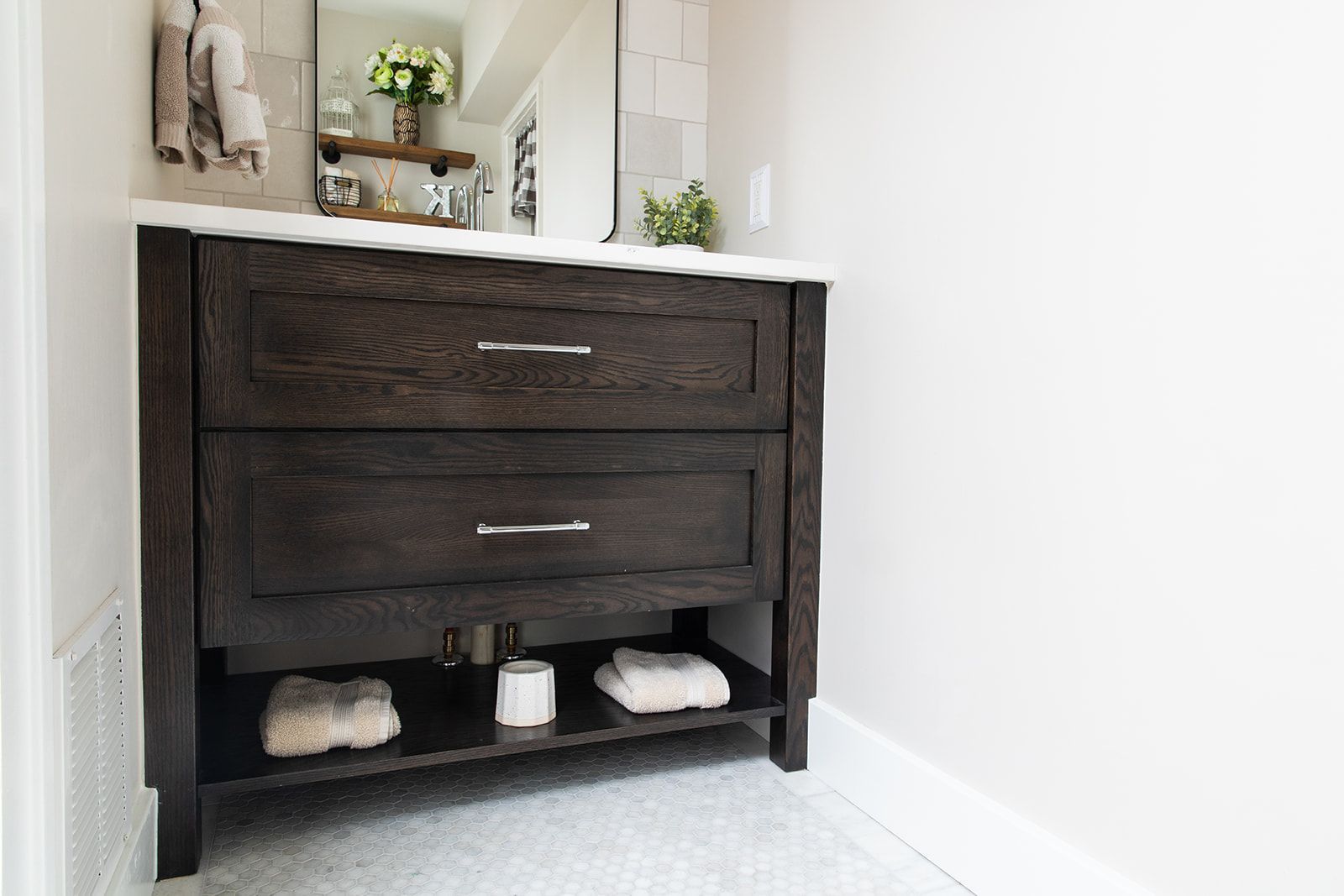 A bathroom vanity with two drawers and a mirror