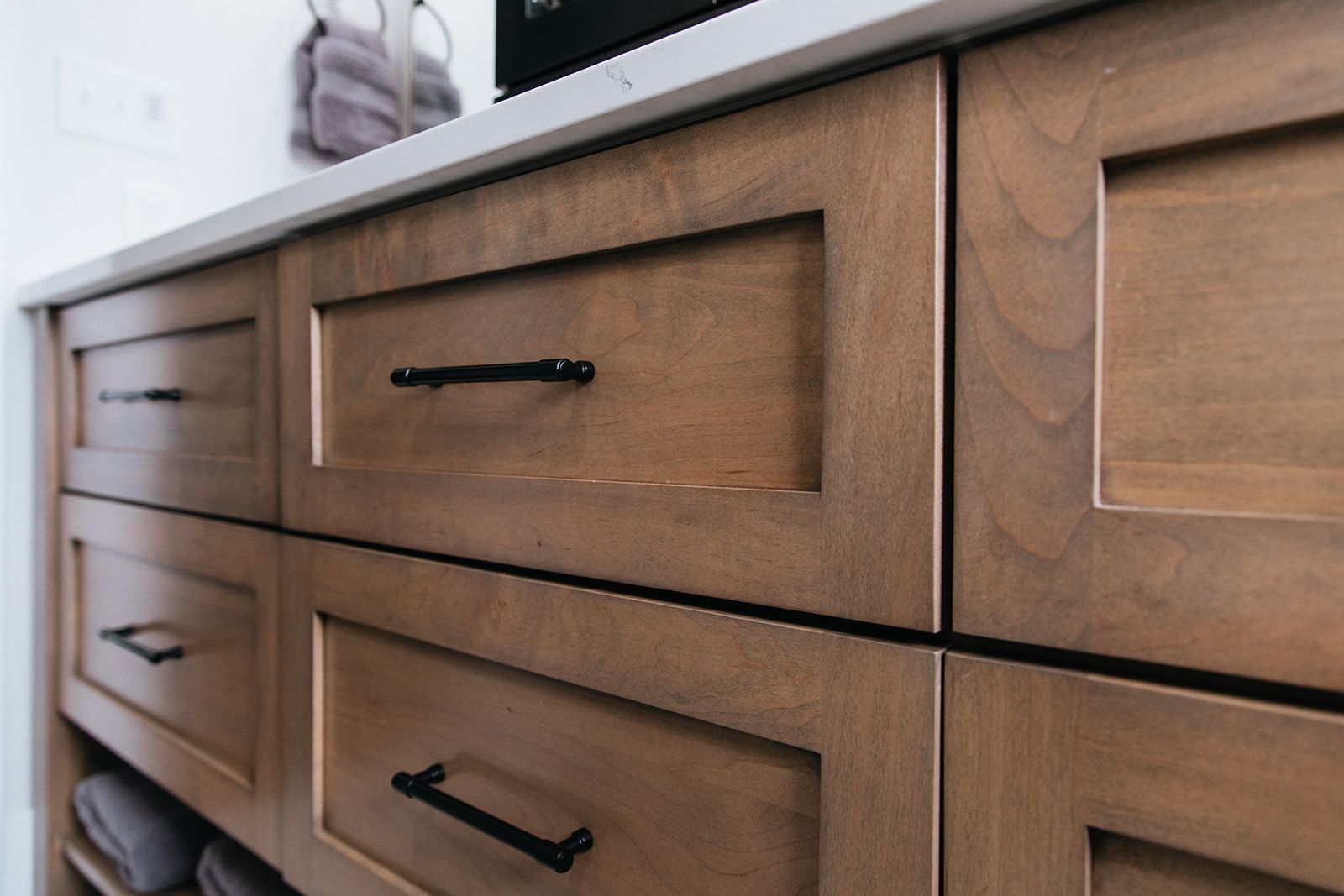 A close up of a dresser with wooden drawers and black handles