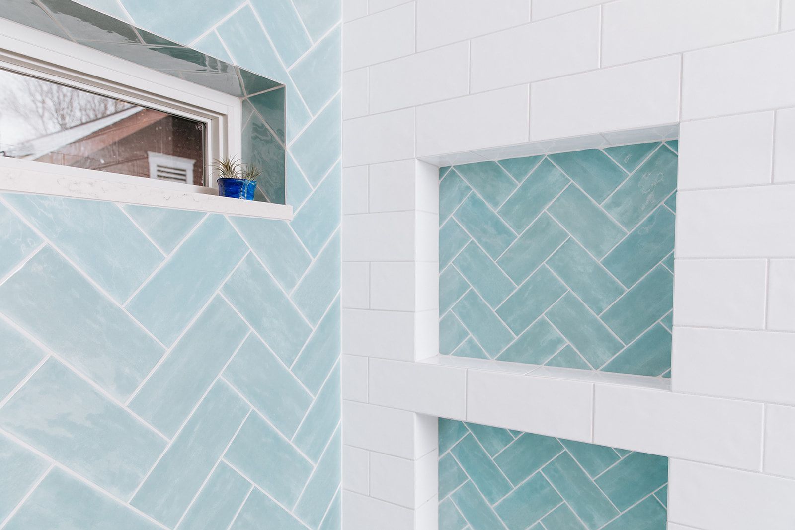 A bathroom with blue and white tiles and a window